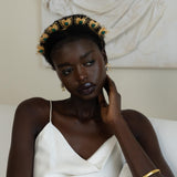 Woman wearing a decorative headpiece and white dress in a classical setting